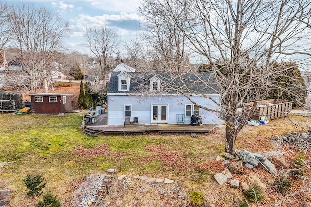 back of house with a storage shed, a yard, and a wooden deck