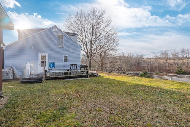 back of house featuring a lawn and a wooden deck