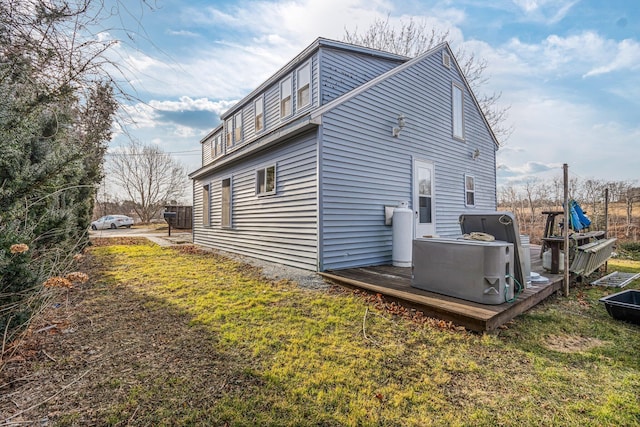 view of side of home featuring a yard and a deck