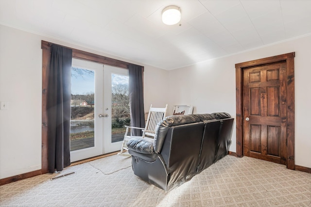 living room with light colored carpet, crown molding, and french doors