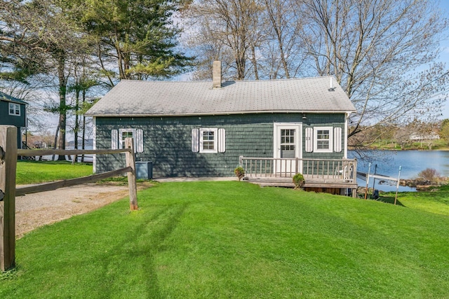 13 W Orchard Ln, Swanville, ME 04915 - rear view of property featuring a lawn, a deck with water view, a chimney, and roof with shingles