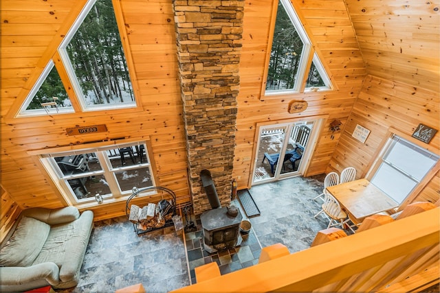 living room with a wealth of natural light, wood walls, and high vaulted ceiling