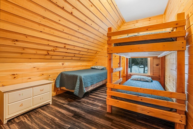 bedroom with wooden walls, dark hardwood / wood-style flooring, and lofted ceiling