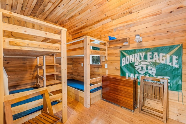 bedroom featuring wood walls, hardwood / wood-style floors, wooden ceiling, and lofted ceiling