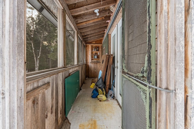 interior space featuring wooden walls and lofted ceiling