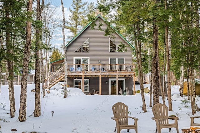 snow covered property with a deck