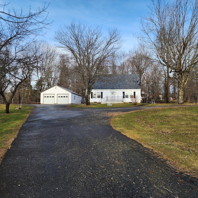 view of front facade featuring an outbuilding, a front yard, and a garage