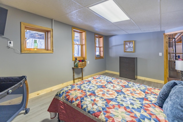 bedroom featuring a paneled ceiling and light hardwood / wood-style floors