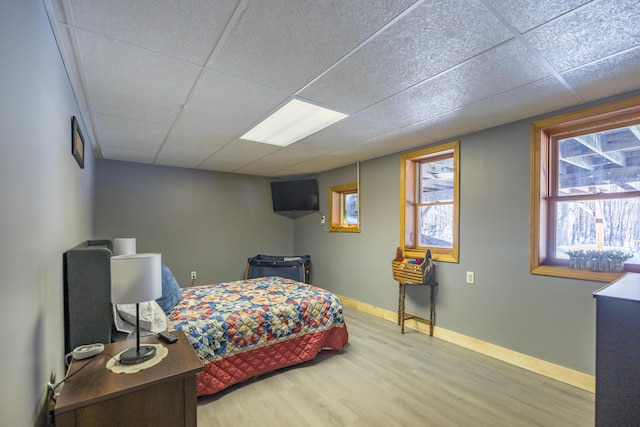 bedroom featuring a paneled ceiling and wood-type flooring