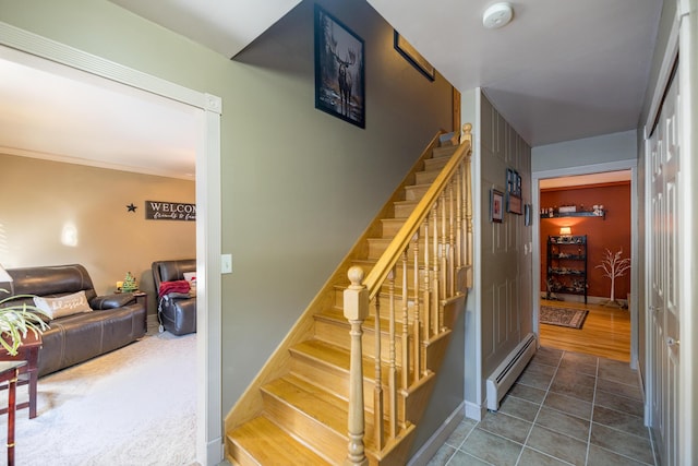 stairway with tile patterned flooring and a baseboard heating unit