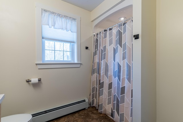 bathroom featuring toilet, curtained shower, and a baseboard heating unit