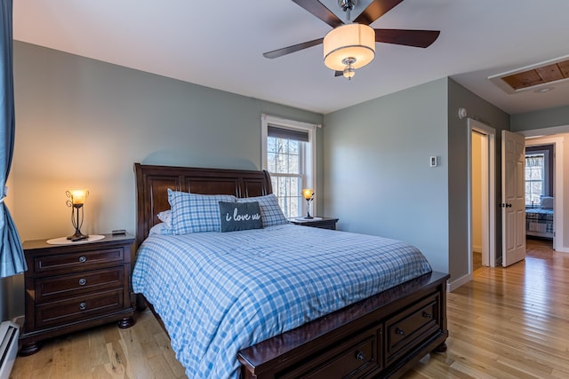 bedroom featuring light wood-type flooring, a baseboard radiator, and ceiling fan