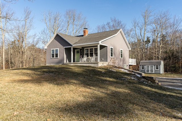 exterior space featuring covered porch, a front yard, and a storage unit