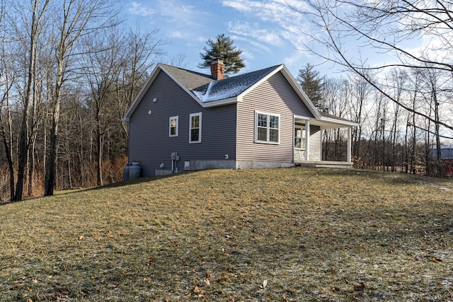 view of side of property with covered porch and a yard