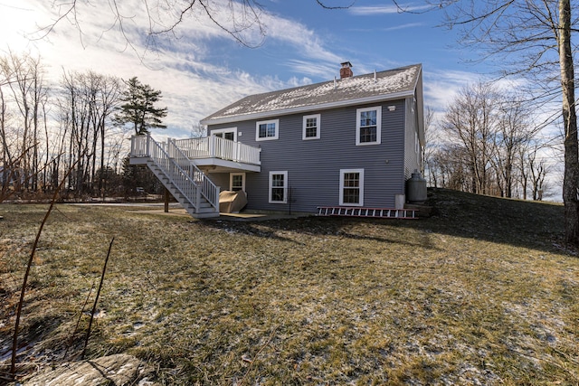 back of property featuring a deck and a lawn