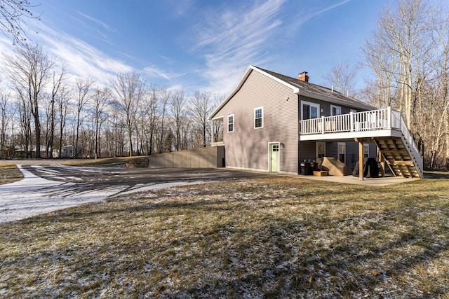 rear view of property featuring a yard and a wooden deck