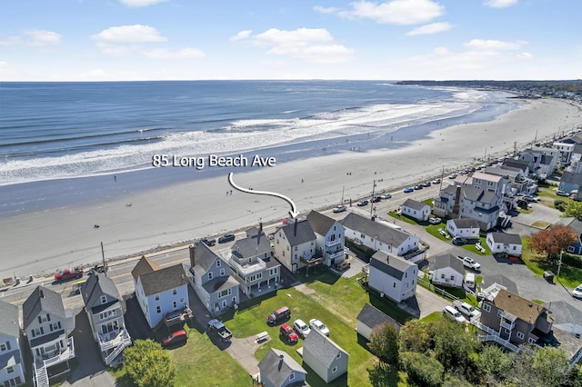 drone / aerial view featuring a view of the beach, a water view, and a residential view