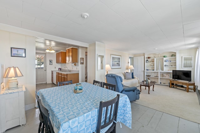 dining room with built in shelves and light carpet