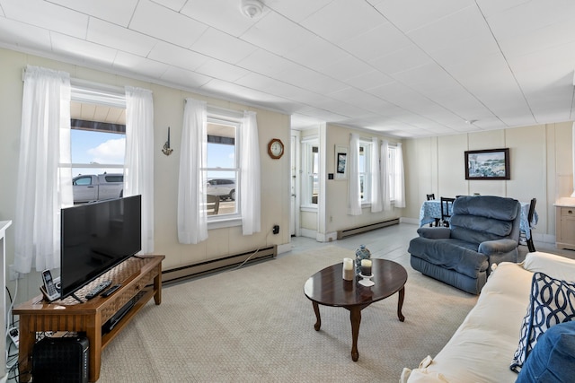 carpeted living area featuring a baseboard heating unit and plenty of natural light