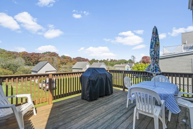 wooden terrace with grilling area and a yard