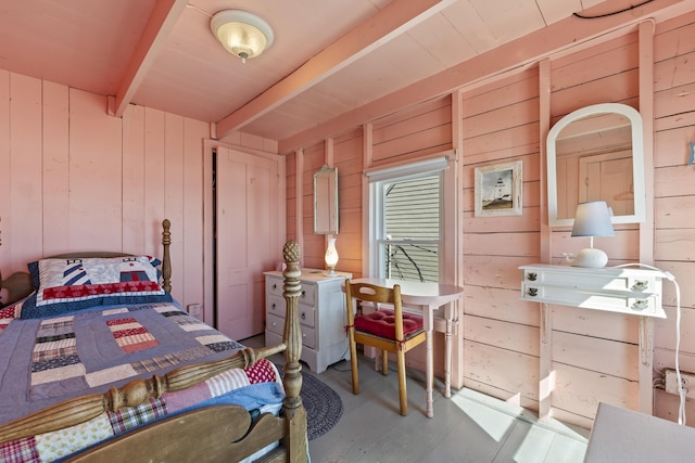 bedroom with beam ceiling and wood walls