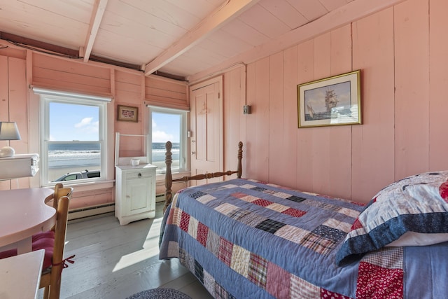 bedroom with beamed ceiling, wood ceiling, a baseboard heating unit, and wooden walls