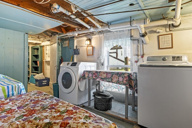 bedroom with wood walls, concrete floors, and separate washer and dryer