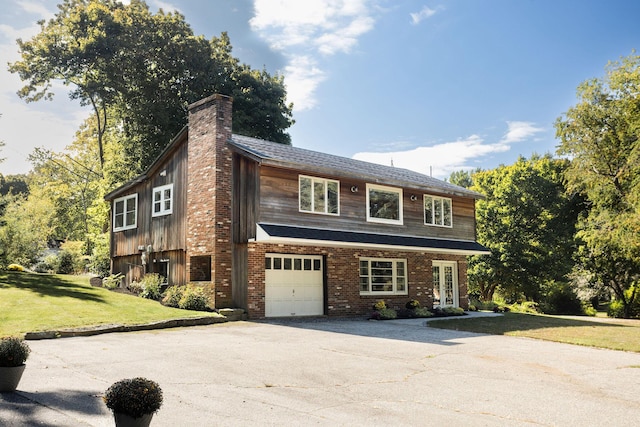 view of front of home with a front yard and a garage