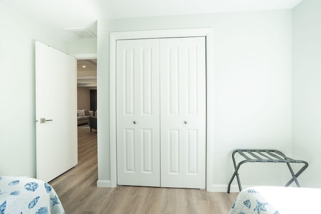 bedroom with light hardwood / wood-style floors and a closet