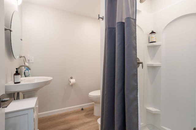 bathroom featuring sink, walk in shower, toilet, and wood-type flooring