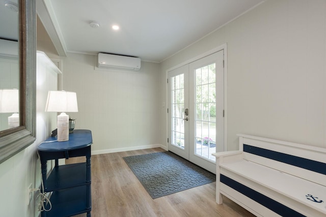 doorway to outside featuring light hardwood / wood-style floors, a wall mounted AC, french doors, and crown molding