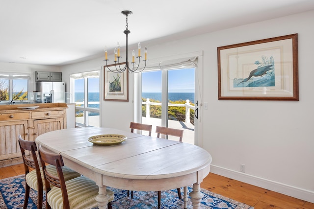 95 Pumpkin Cove Rd, Bristol, ME 04554 - dining area with a water view, a chandelier, and light hardwood / wood-style floors
