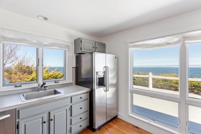 95 Pumpkin Cove Rd, Bristol, ME 04554 - kitchen featuring gray cabinets, sink, stainless steel fridge, a water view, and light hardwood / wood-style flooring