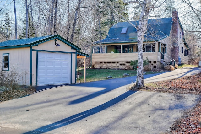 exterior space with covered porch, an outdoor structure, and a garage