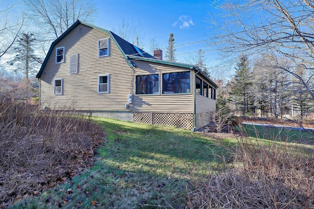 view of side of property featuring a sunroom and a yard