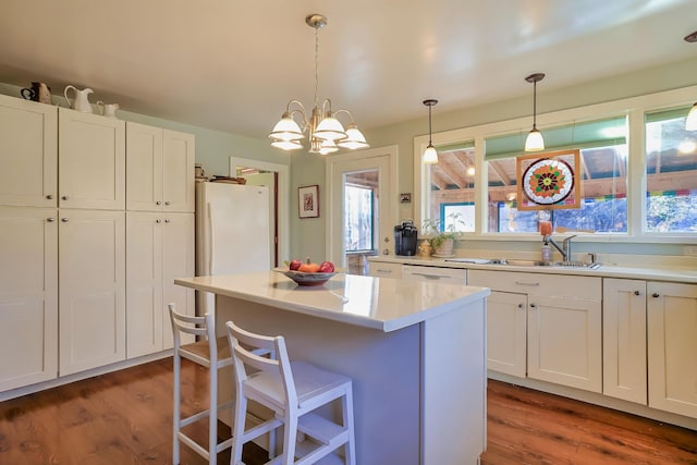 kitchen with decorative light fixtures, dark hardwood / wood-style floors, a notable chandelier, and sink