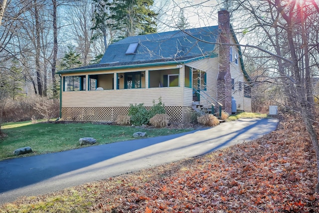 view of property exterior featuring a porch and a yard