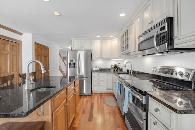 kitchen with white cabinets, appliances with stainless steel finishes, and a kitchen bar