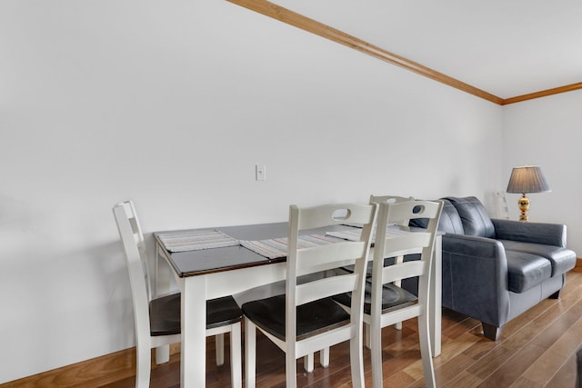 dining room featuring crown molding and dark wood-type flooring