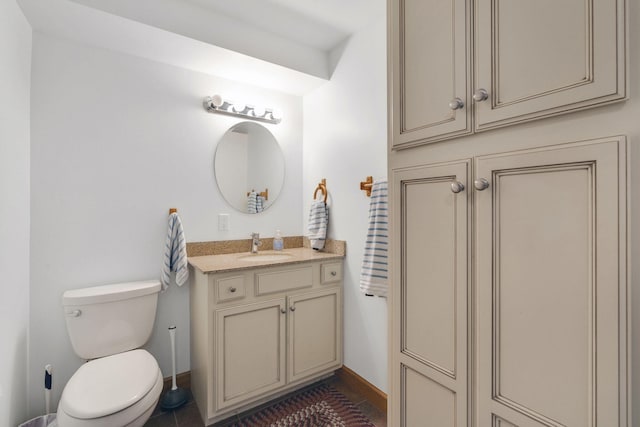 bathroom featuring tile patterned flooring, vanity, and toilet