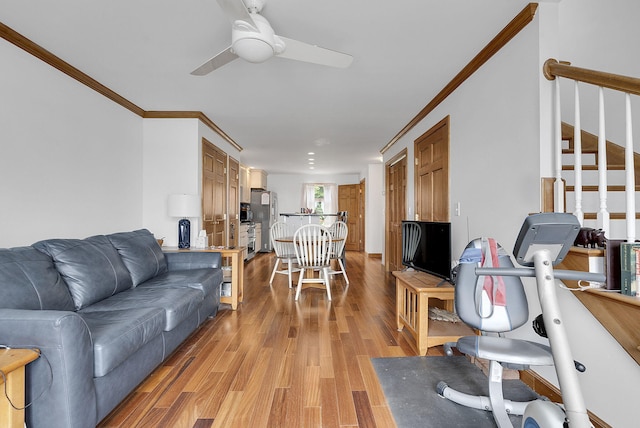 living room with crown molding, ceiling fan, and light hardwood / wood-style floors