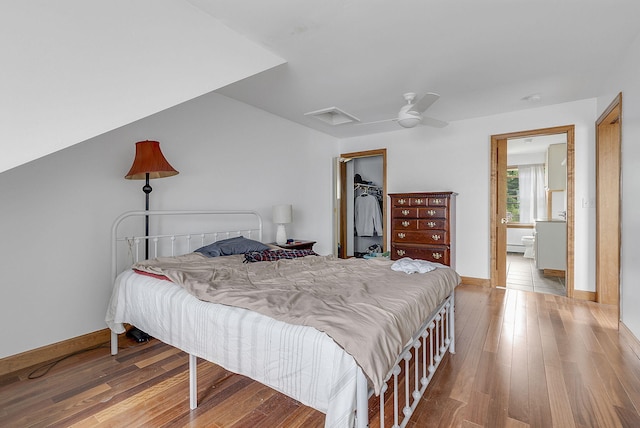 bedroom with a walk in closet, ceiling fan, a closet, and wood-type flooring