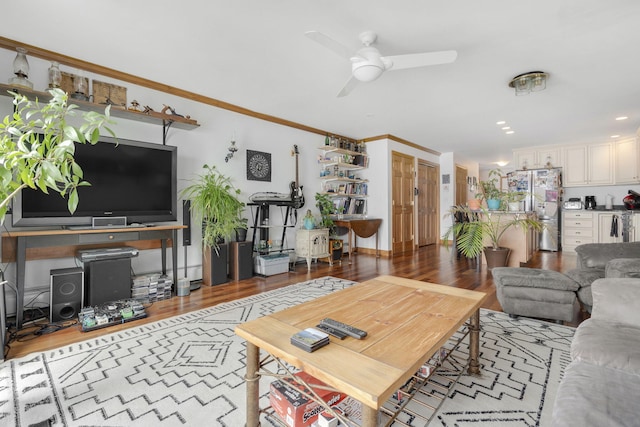 living room featuring wood-type flooring, ceiling fan, and crown molding