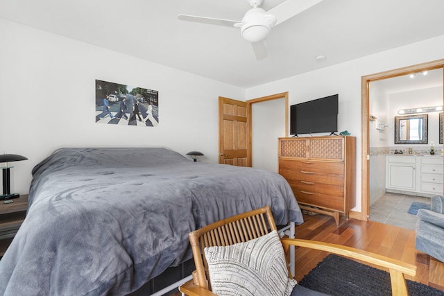 bedroom with light wood-type flooring, connected bathroom, and ceiling fan