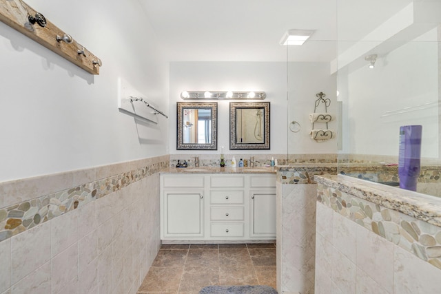 bathroom featuring vanity and tile walls