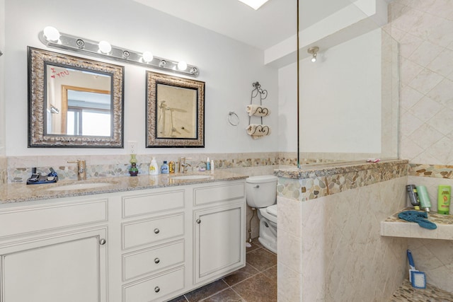 bathroom with tile patterned flooring, vanity, tile walls, and toilet