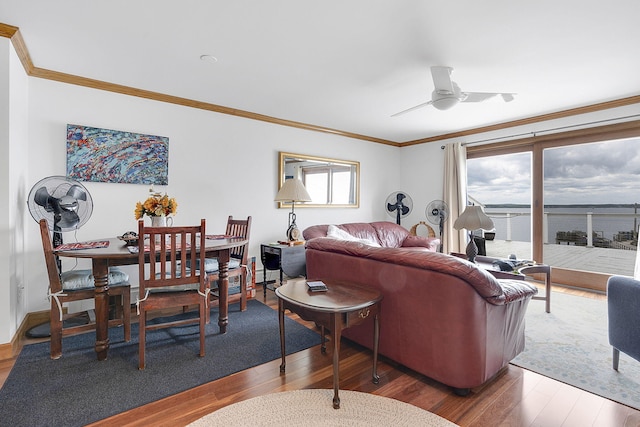 living room featuring plenty of natural light, a water view, hardwood / wood-style floors, and ornamental molding