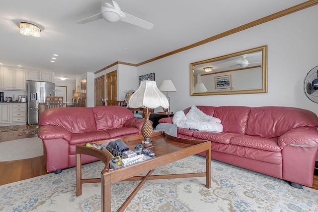 living room featuring light hardwood / wood-style floors, ceiling fan, and crown molding