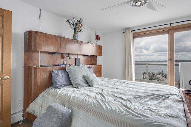 bedroom featuring hardwood / wood-style flooring, ceiling fan, and a baseboard heating unit