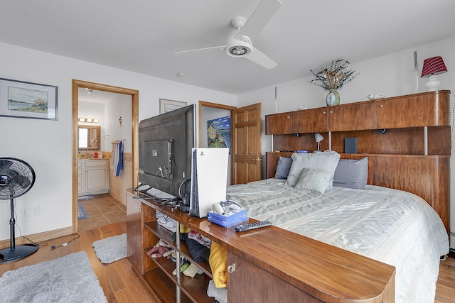 bedroom with ensuite bath, ceiling fan, and light hardwood / wood-style flooring